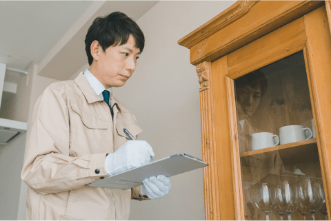 家具を査定する作業着姿の男性