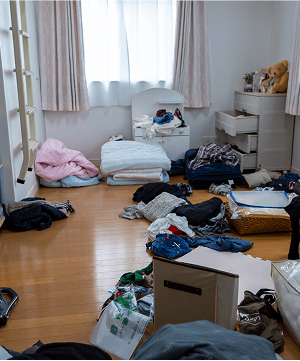収納に収まらず、床や家具の上に服や物が置かれている部屋